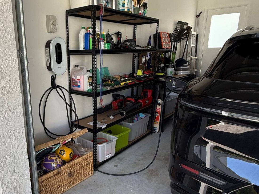 Home EV charger on a garage wall, charging the car