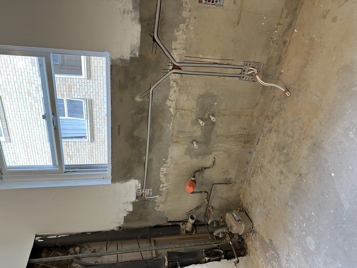 Conduit and cabling roughed in along a wall